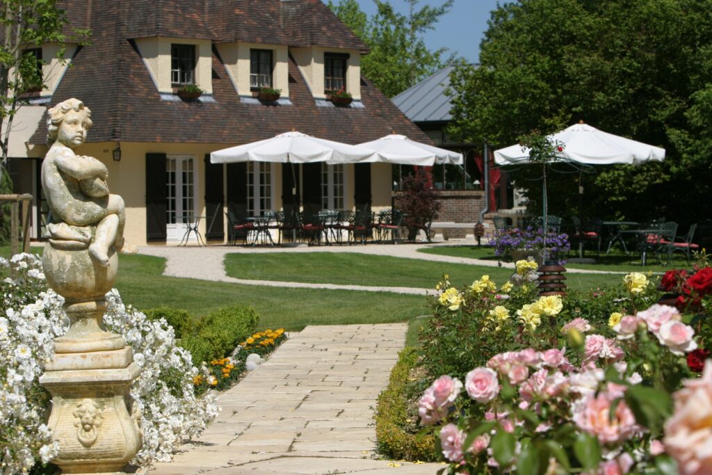 Il giardino, il bar e la veranda dell'Hostellerie La Briqueterie, esclusivo Relais & Châteaux in Champagne.