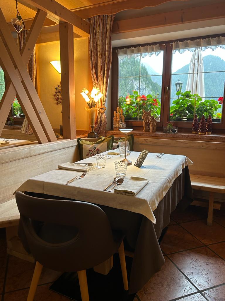 Tavolo con vista al ristorante Baita Dovich di Rocca Pietore. L'anima di montagna si fonde con un gusto autentico per l'eleganza. Tutto il sapore delle Dolomiti tra alta quota e alta cucina.