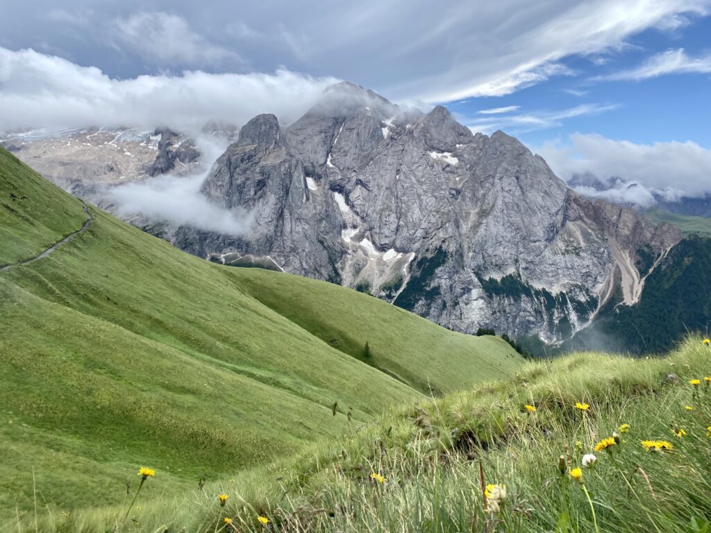 Il sentiero Viel del Pan taglia distese di prati alpini con spettacolare vista sul massiccio della Marmolada