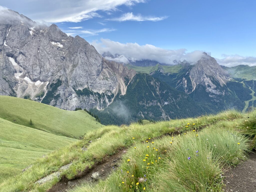 Il percorso dal rifugio Viel del Pan al Passo Pordoi, immerso nei prati alpini in fiore, con vista mozzafiato sulle cime circostanti