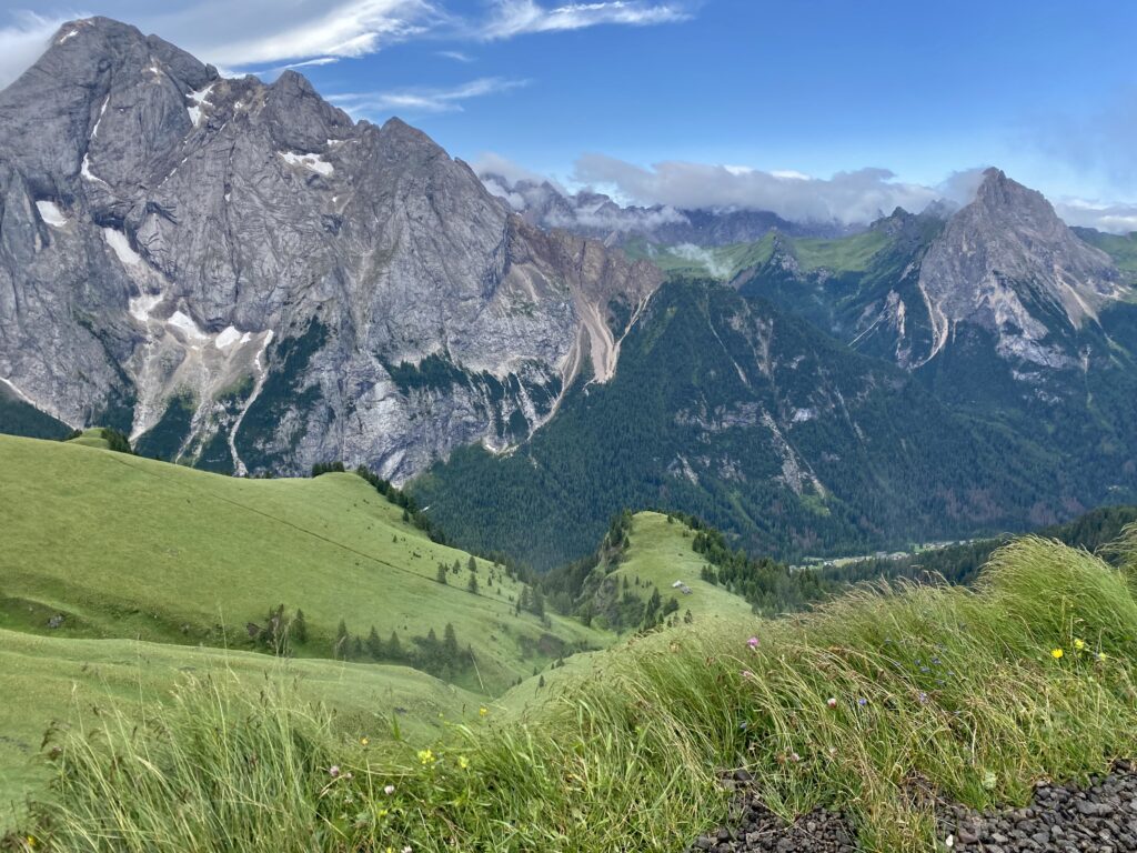 Colline verdi e cime innevate che circondano il sentiero Viel del Pan
