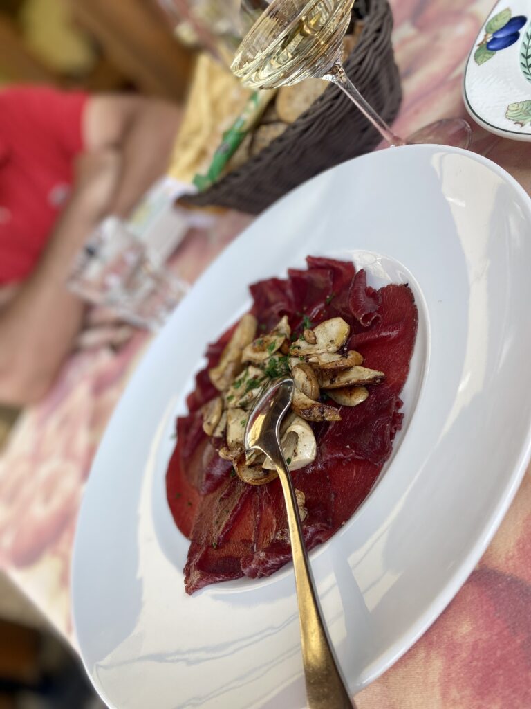 Carpaccio di cervo e funghi porcini. Il gusto autentico delle Dolomiti tra alta quota e alta cucina.