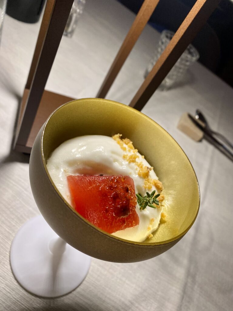 Spuma fredda al parmigiano, crumble salato e cubetto di anguria. Il benvenuto della cucina secondo lo chef di Baita Dovich, Rocca Pietore.